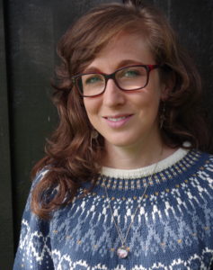 Author photo of woman in glasses with blue knitted jumper